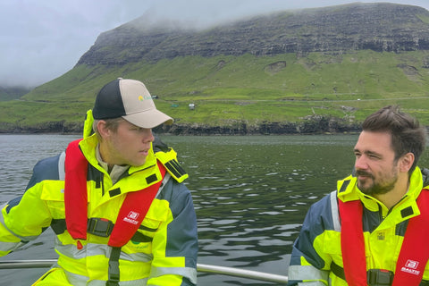 Oskar från Gårdens och en medarbetare från Hiddenfjord i båt vid odlingarna på Färöarna